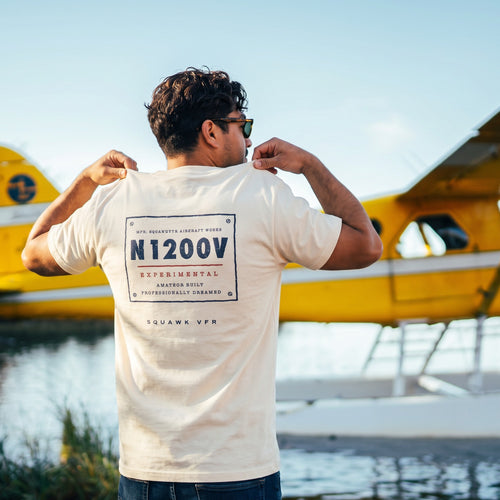 On-model — Certified Experimental Tee back print with N1200V data plate, worn on a floatplane dock, SquawkVFR