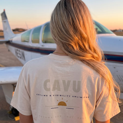 On-model — C.A.V.U Tee back print, Ceiling And Visibility Unlimited, worn at golden hour beside a Bonanza, SquawkVFR