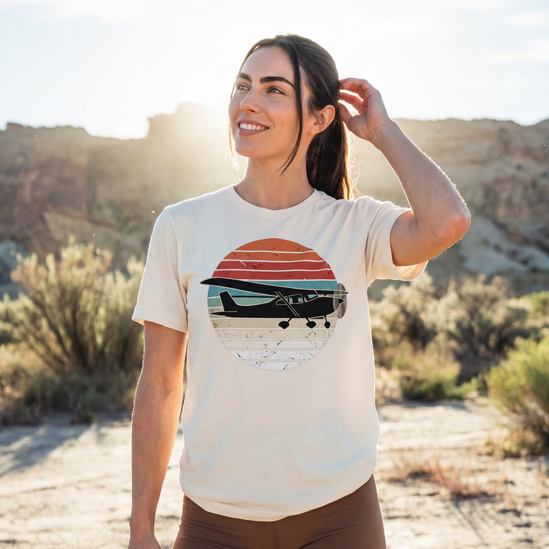 On-model — Vintage Aviation Tee with retro airplane sunset print, worn in high desert scrub at golden hour, SquawkVFR